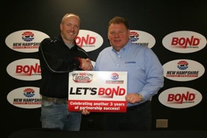 New Hampshire Motor Speedway vice president and general manager Jerry Gappens (right) and Bond Auto Parts vice president of marketing Mark Mast shake on a new deal that makes Bond the "Official Auto Part Retailer" of NHMS. 